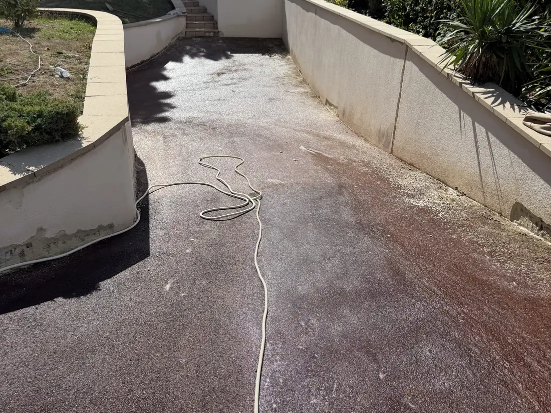 Allée en béton désactivé encrassée, voile vert et traces noires avant nettoyage