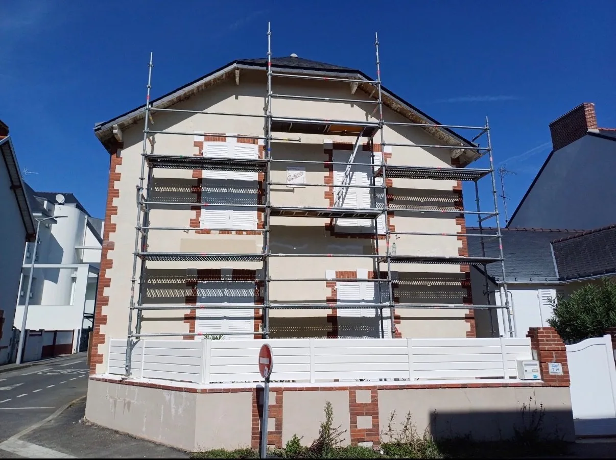 Façade de maison avant ravalement, échafaudage en place